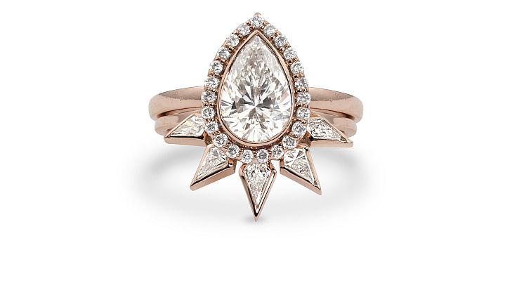 Julez Bryant Gia wedding ring set in 14-karat rose gold set with a pear-shaped, 1-carat diamond with micro halo and kite shaped white diamond crown wedding band. 