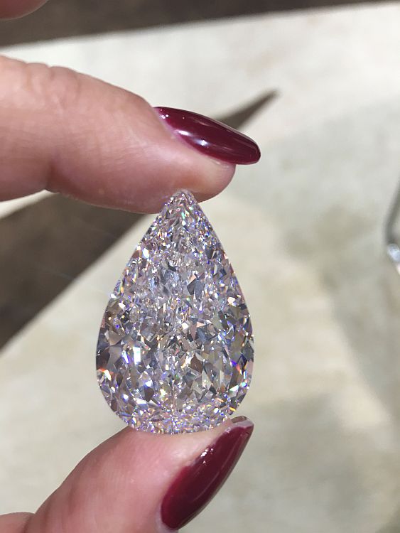 Tracey Ellison holding an AA Rachminov flawless pear shape diamond.