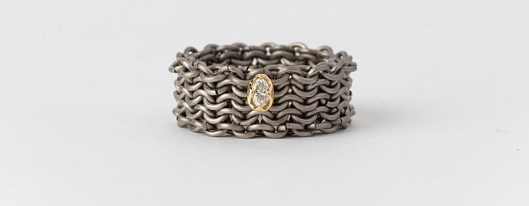 Alison Evans. Knitted titanium ring with a single diamond in an 18-karat yellow gold collet. 