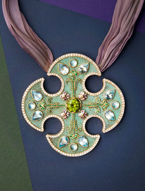 Prince Dimitri medieval-style cross in 20-karat yellow gold and oxidized bronze. In the center is a 6.29 carats peridot surrounded by blue topaz, moonstones, diamonds, tsavorites, green spinels and pink sapphires. Image: Mark Roskams. 
