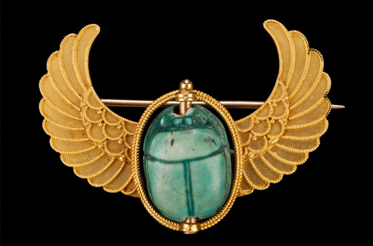 Brooch Featuring an Ancient Scarab in a Modern Winged Mount, unmarked, (plaquette) New Kingdom, ca. 1539 – 1077 BCE; (gold mount) late 1800s – early 1900s, glazed steatite and gold (modern), 2.6 x 3.6 x 1.5 cm. Mrs. Kingsmill Marrs Collection, 1926.86