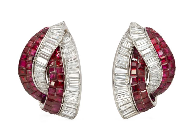 A pair of Retro invisibly set ruby and baguette diamond earrings of bypass design, in platinum with clip backs. Atw 11.50 ct. diamonds; atw 14.00 ct. rubies. Kentshire