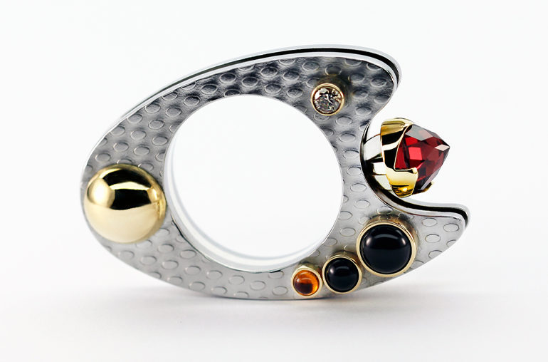 One-of-a kind stainless steel ring named Celestial Poem with 18K gold, champagne diamond, citrine, onyx, and a modern rose cut garnet cut specially for the ring; Courtesy Pino Designs