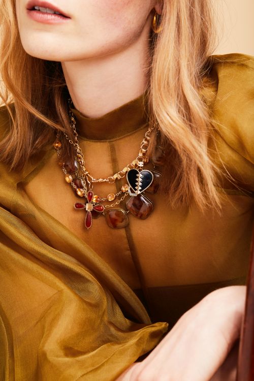 Metier SF mixed necklace on model shot featuring Harwell Godfrey black onyx heart in 18-karat yellow gold mixed with Georgian citrine paste riviere and Georgian dendritic agate and Victorian watch fob chain.