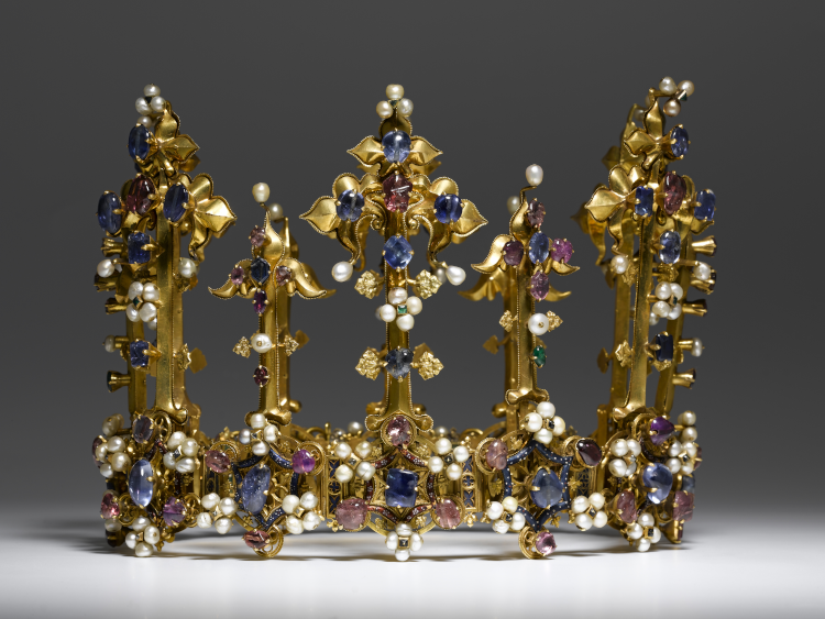 This tall gold fleuron crown was made c. 1380 for Anne of Bohemia (1366-1394), Queen of England. It is set with blue and pink sapphires, plus pearls and other smaller gemstones.