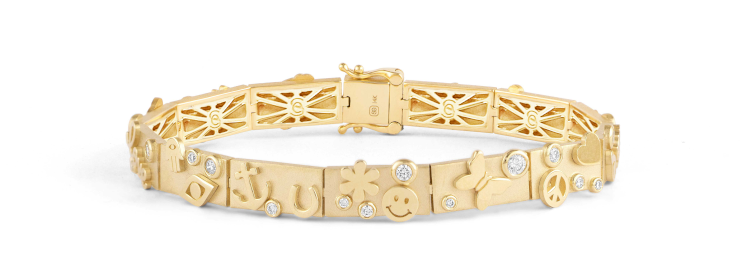 Icon bracelet in 14-karat yellow gold and diamonds, designed for Sydney Evan's 20th anniversary. It features 20 icons + one for good luck:  an elephant, a clover, a wishbone, a Saturn, a star, a love script, a hamsa, an evil eye, an anchor, a horseshoe, a happy face, a daisy, a butterfly, a peace sign, a heart, an eyelash evil eye, a ladybug, a bee, a moon, a starburst, and a monstera leaf. Photo: Sydney Evan.