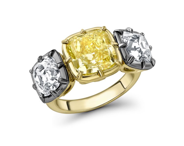 Emma Clarkson Webb Ring in 18-karat yellow gold centering a yellow diamond with old mine cushion-cut diamonds on either side, in a Georgian setting with a black rhodium finish.