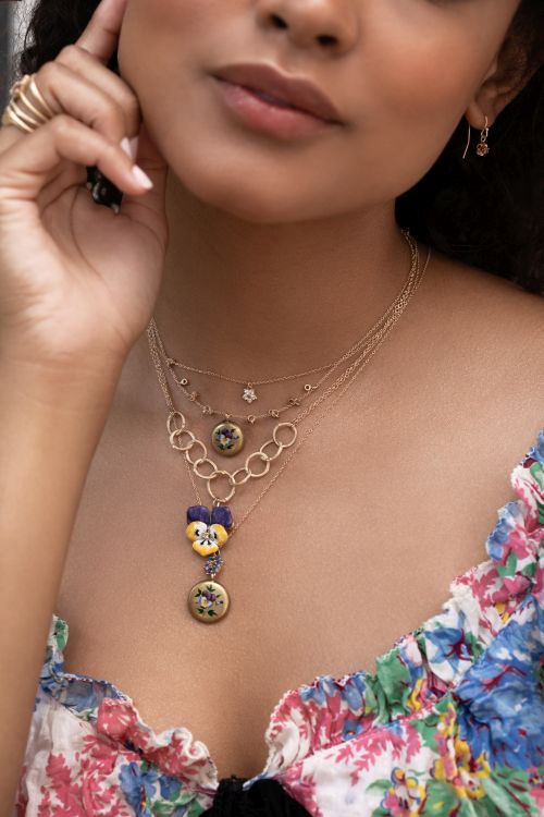 Model wearing 14-karat necklaces including tiny diamond Daisy necklace, dangling pods necklace set with multicolor sapphires and vintage enamel pendant, twig necklace with vintage pansy enamel pendant, sapphire circlet and vintage enamel pendant. Photo: Sofia Kaman. 