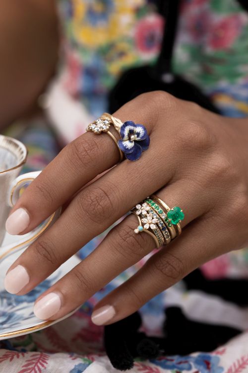 14-karat yellow gold rings including ring with vintage enamel flower, emerald ring, emerald stacking band, diamond Daisy twig stacking bands, turquoise and diamond bezel stacking bands. Photo: Sofia Kaman. 
