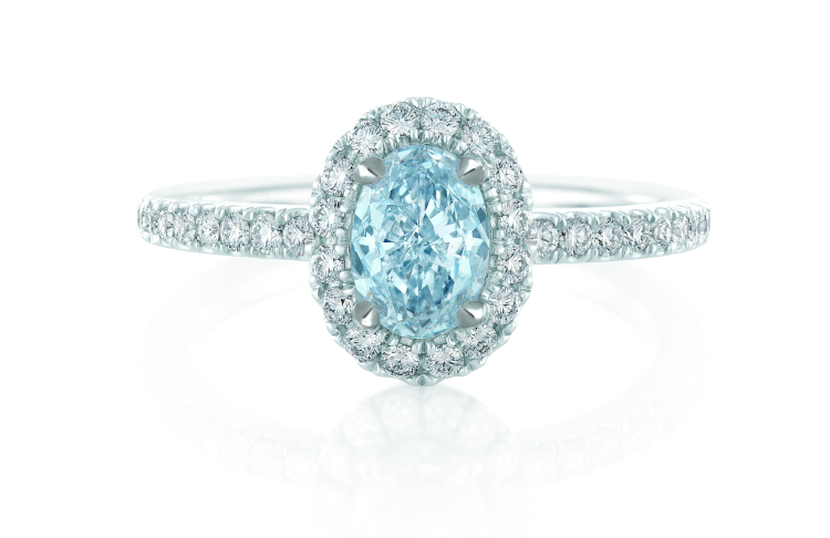 De Beers ring in platinum with oval-cut blue diamond, embraced by a micropavé halo setting. Photo: De Beers.