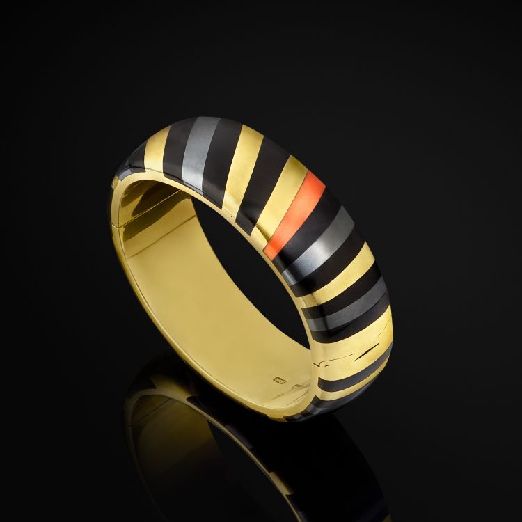 Gold bracelet by Angela Cummings for Tiffany & Co. with inlaid stripes of black onyx, coral, and hematite, c. 1980 (Rago/Wright Auctions)
