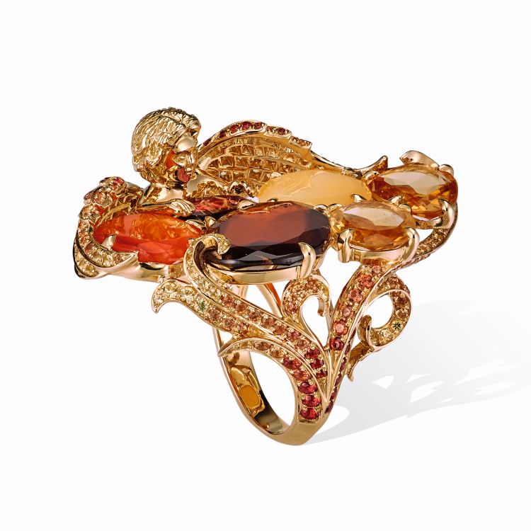 Putti ring from the Amber Chamber collection set with opal, almandine
garnet, citrine, chalcedony, hessonite garnet, orange and yellow sapphires, in 18-karat yellow gold. The shank is decorated with plumes of feathers, 2019. (Lydia Courteille)