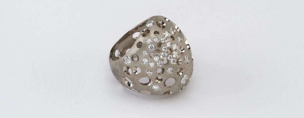 Puffball Void Dome ring in 18-karat grey gold is set with round diamonds. (Studio Renn)